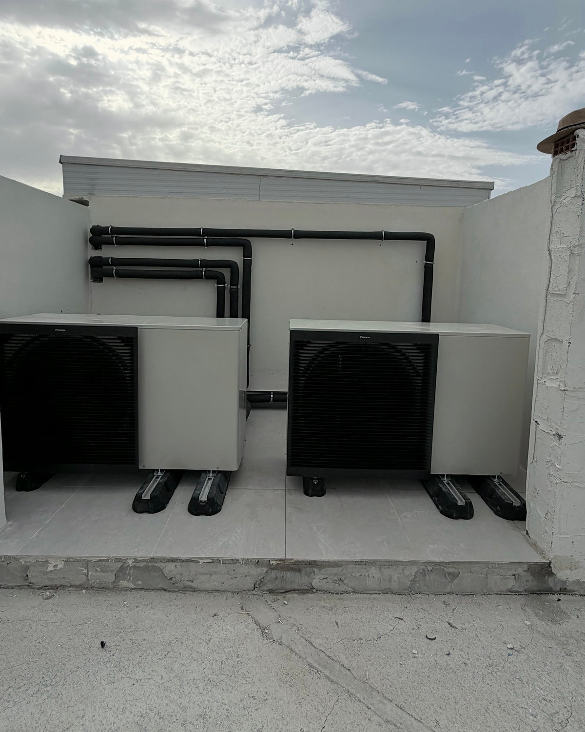 Dos bombas de calor aerotérmicas monobloc sobre antivibratorios, con el trazado hidráulico aislado registrado en pared.