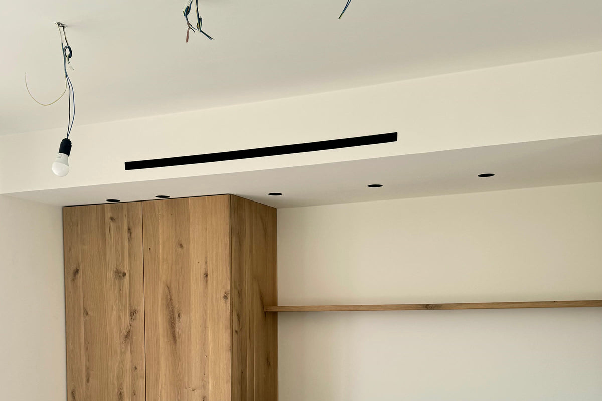 Difusor lineal integrado en el cajón de techo de una cocina terminada: la instalación resuelta sin comprometer el acabado.