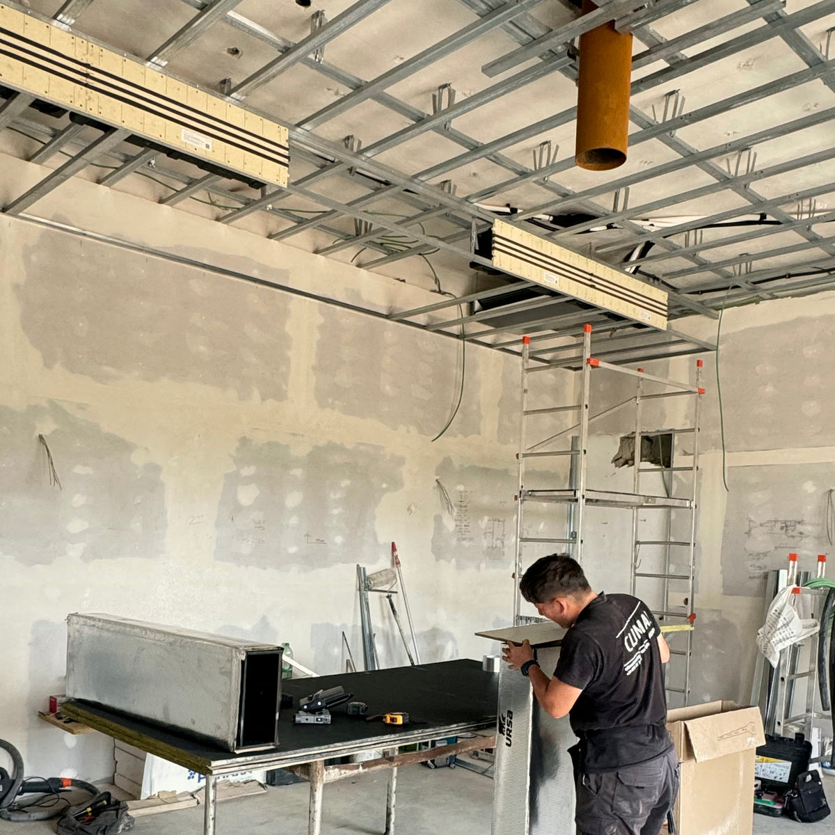 Montaje de conductos de panel autoportante sobre estructura de falso techo durante la ejecución de la instalación.