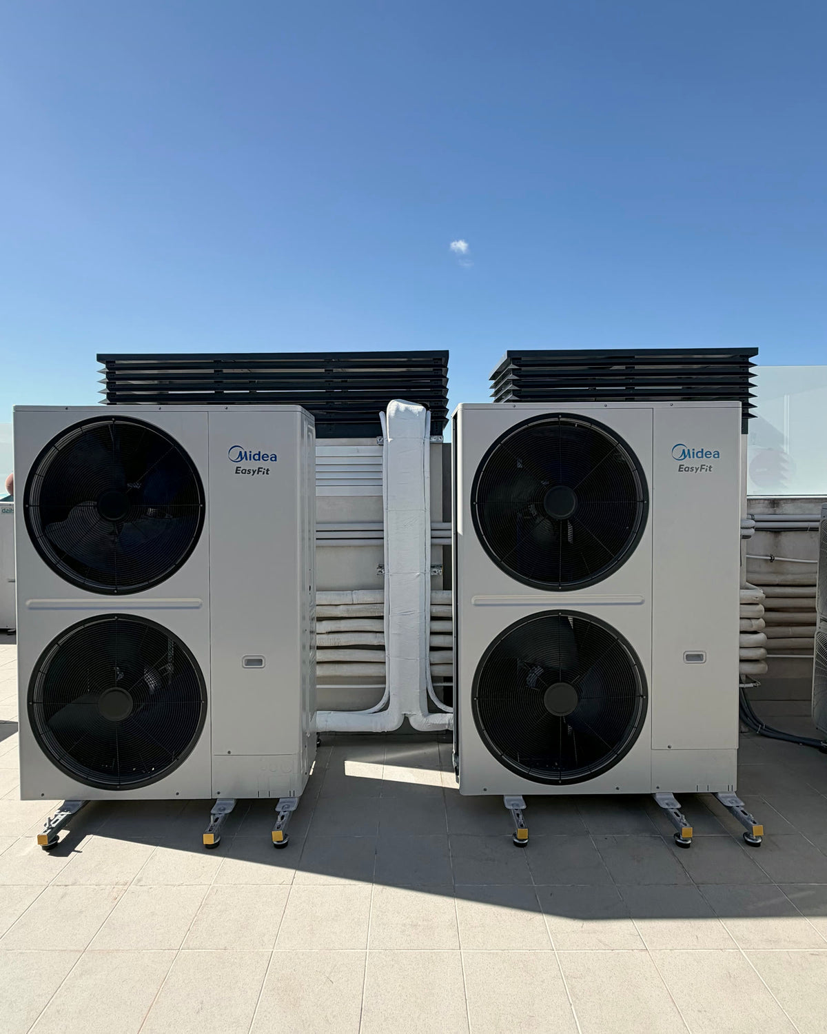 Dos unidades exteriores de sistema VRF instaladas en cubierta, con tubería frigorífica aislada y celosía de protección.