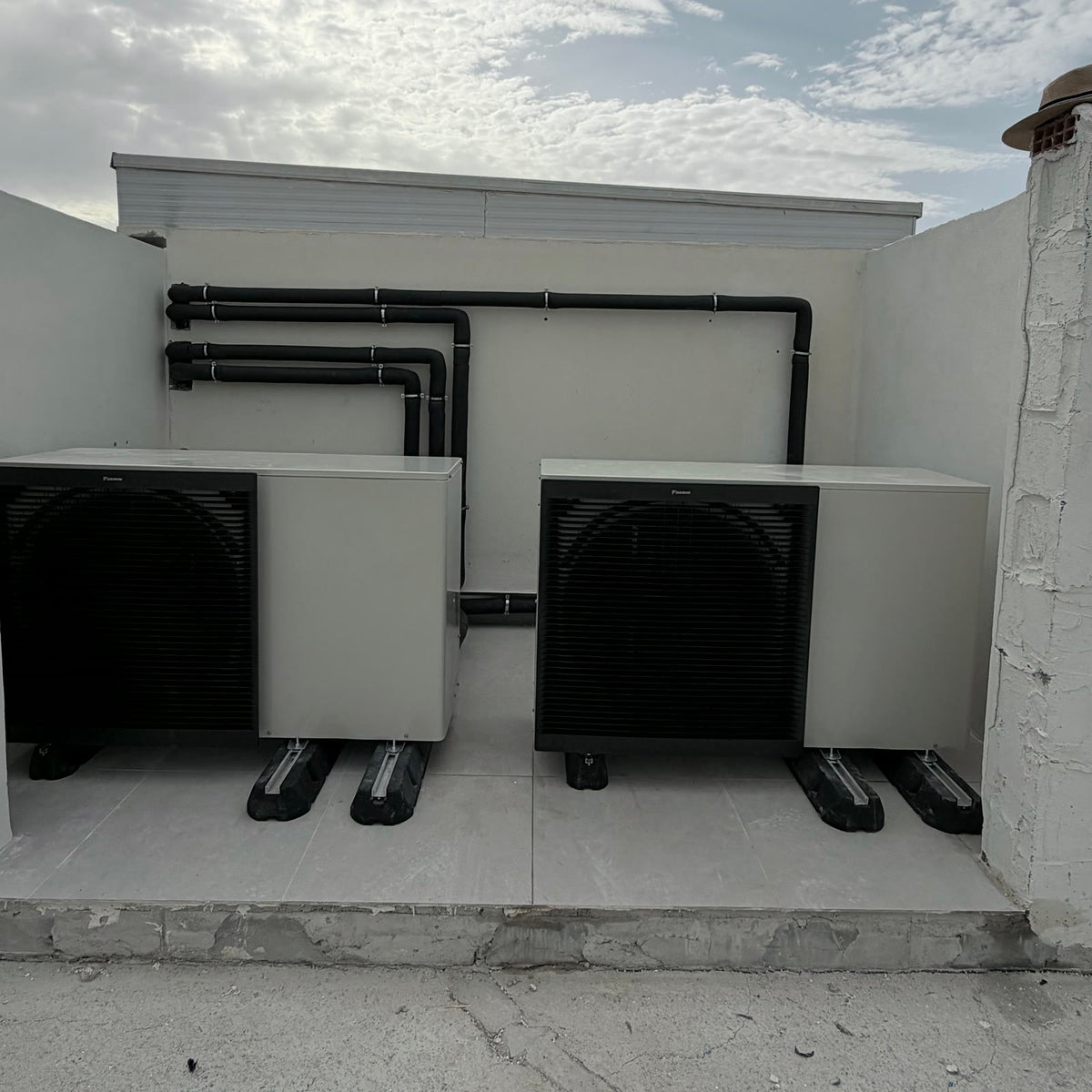 Dos bombas de calor aerotérmicas monobloc sobre antivibratorios, con el trazado hidráulico aislado registrado en pared.